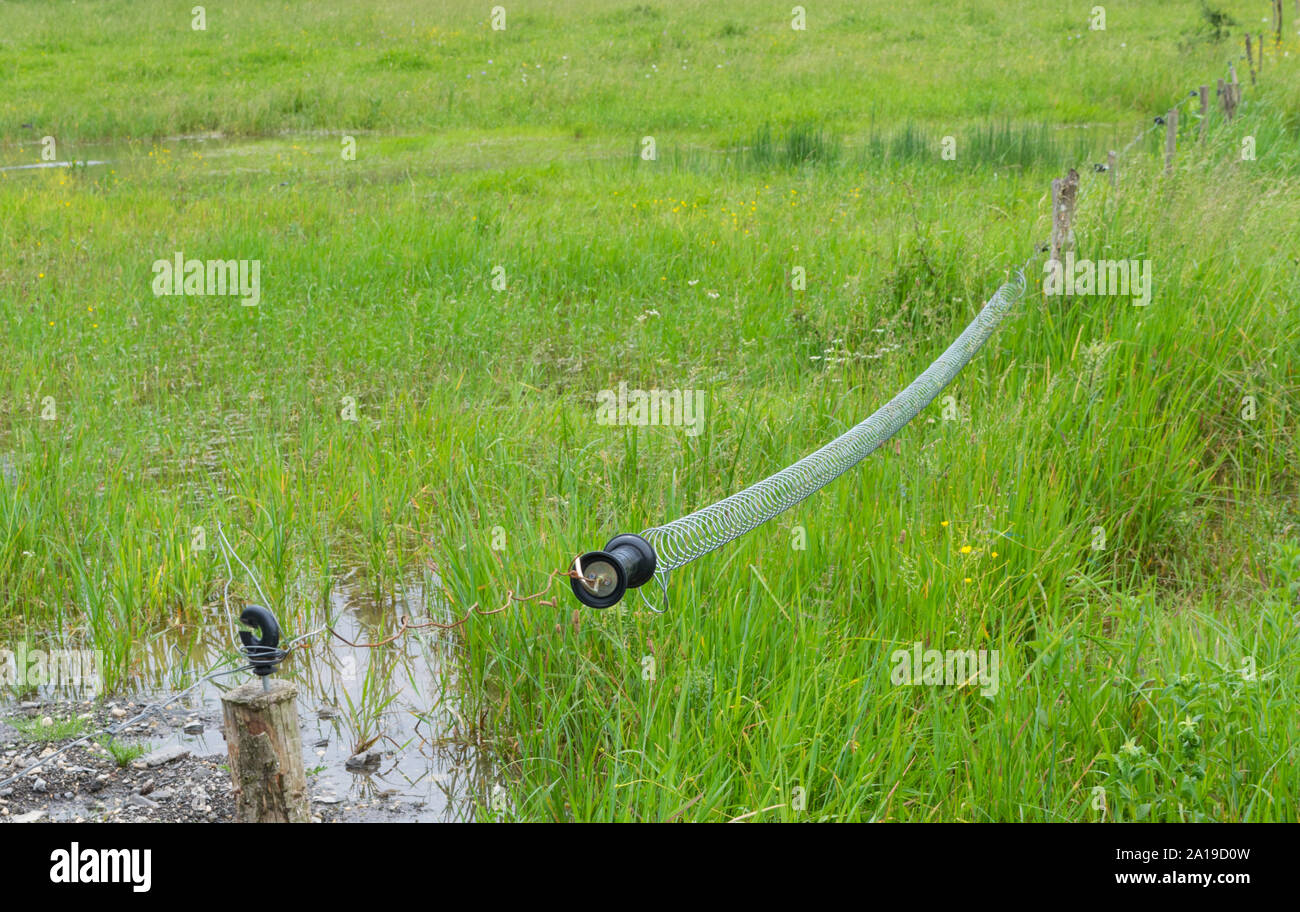 farm electric fence spring insulator access point Stock Photo