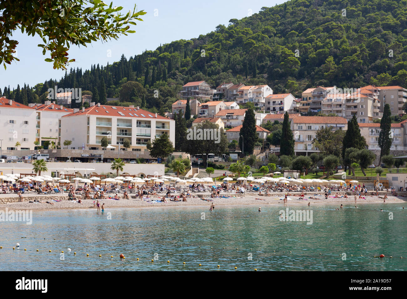 Croatia beach; Tourists sunbathing on Sunset Beach just outside the old town, Dalmatian coast at Dubrovnik Croatia Europe Stock Photo