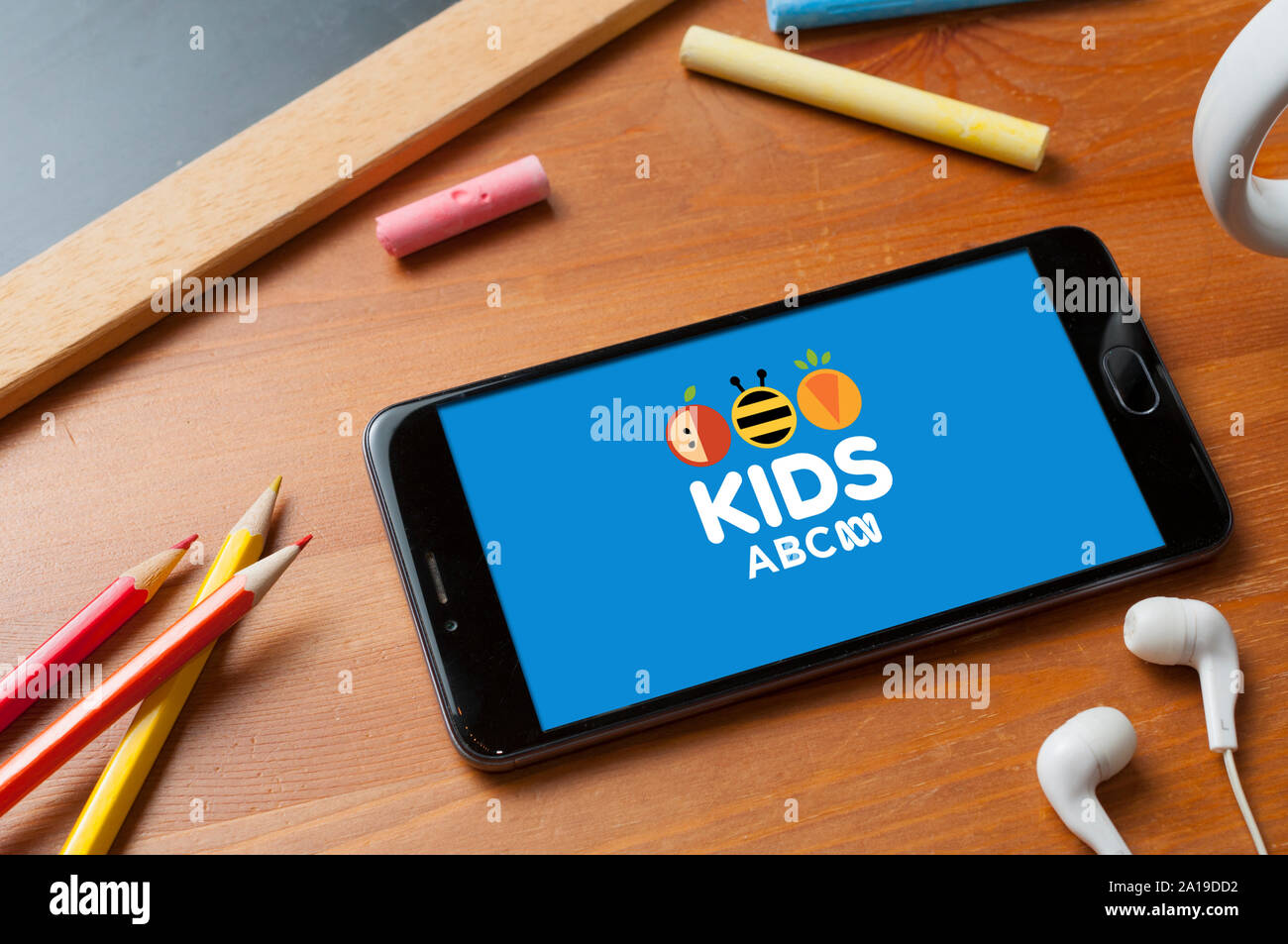 Carrara, Italy - September 25, 2019: Watching the kid's channel of the Australian television station ABC on a table with headphones, pencils and a sma Stock Photo