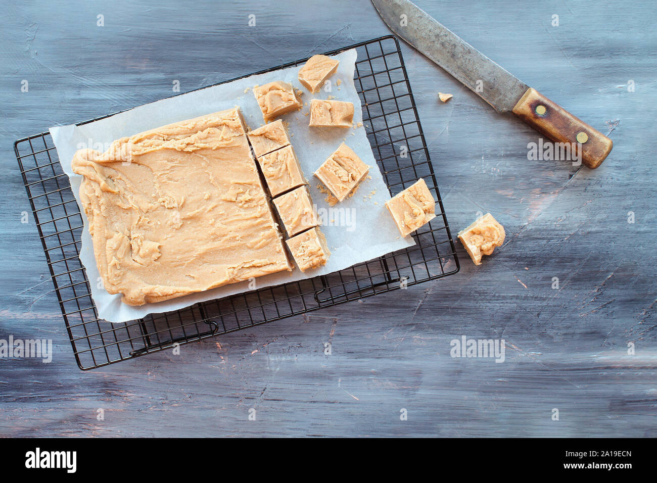 Block of delicious, homemade peanut butter fudge being cut into squares
