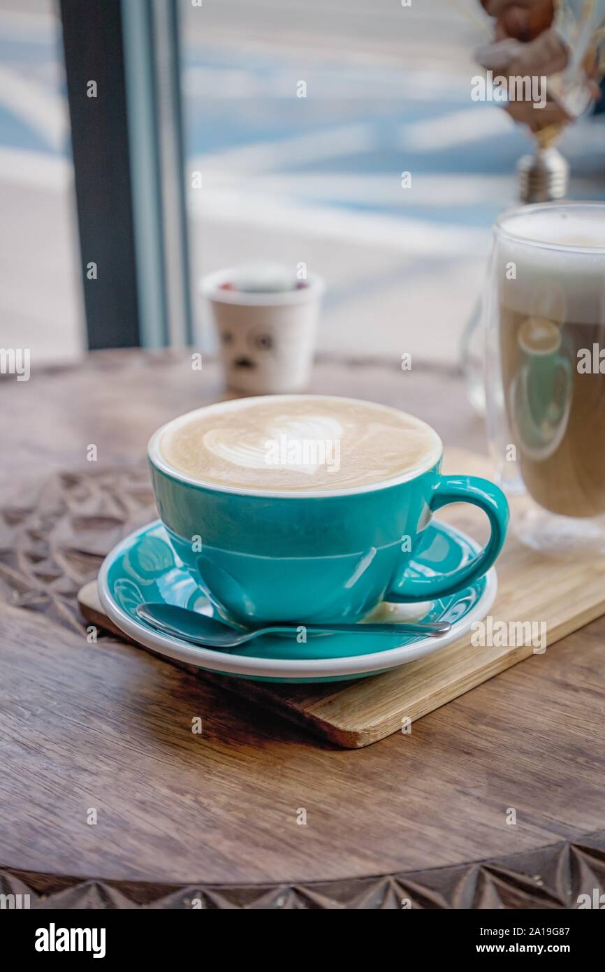 https://c8.alamy.com/comp/2A19G87/green-turquoise-cup-of-coffee-cappuccino-with-heart-on-a-wooden-table-2A19G87.jpg