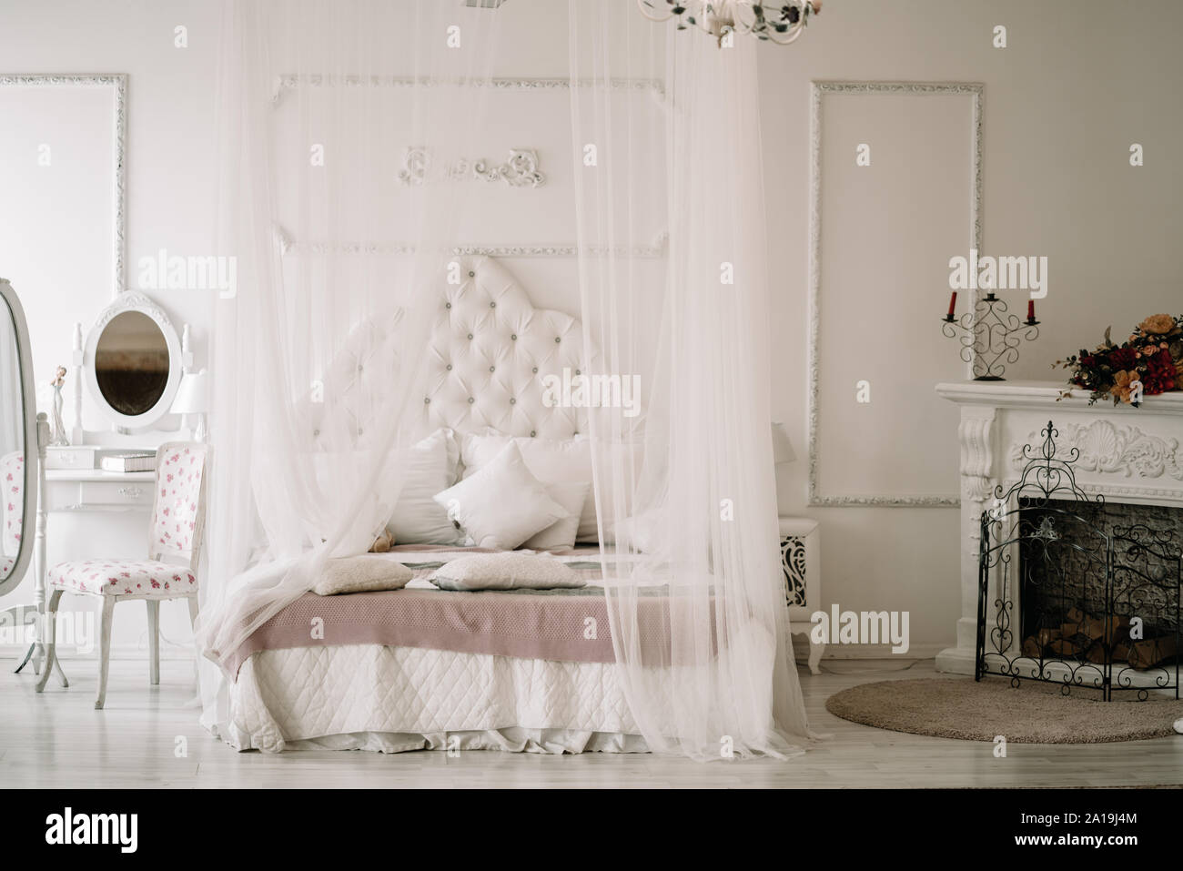 White bedroom interior with nobody. large cozy bed with a white canopy and  oval dressing mirror with dressing table Stock Photo - Alamy, image size:1300x957