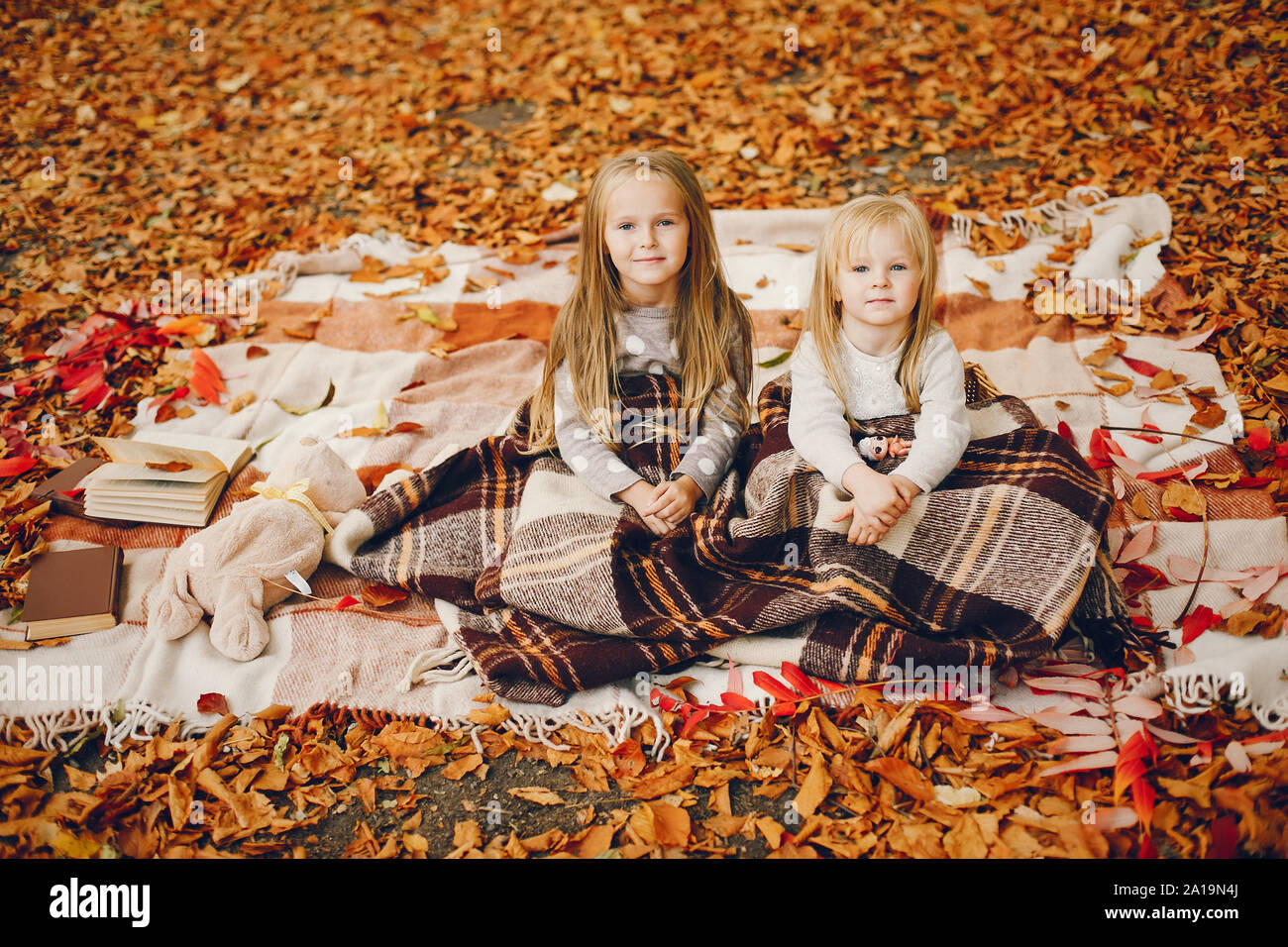 Cute little girls in a autumn park Stock Photo - Alamy
