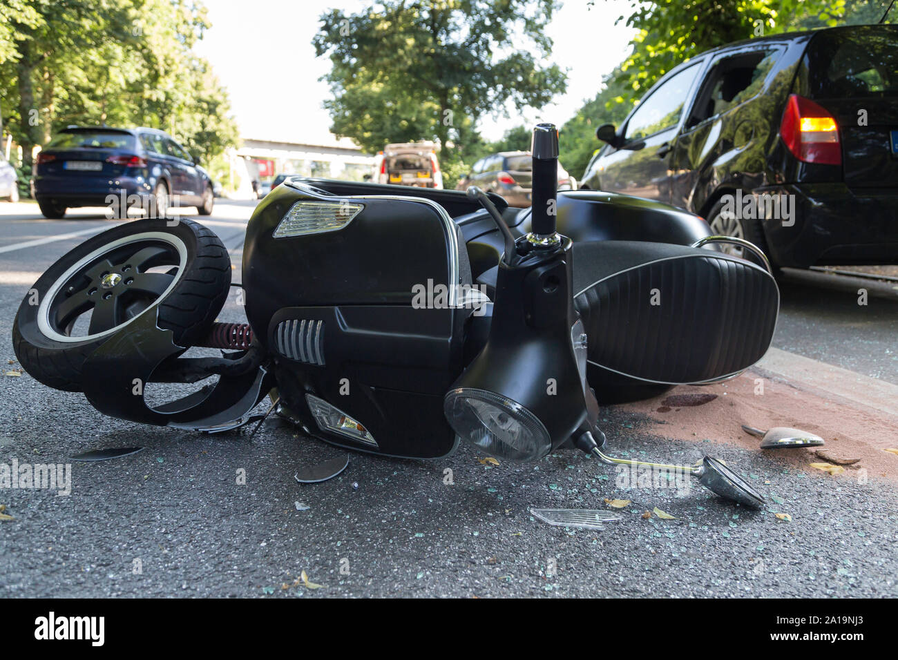black scooter lying on the street after crash Stock Photo