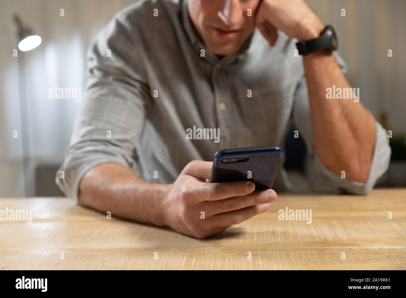Young man at home using a smartphone Stock Photo