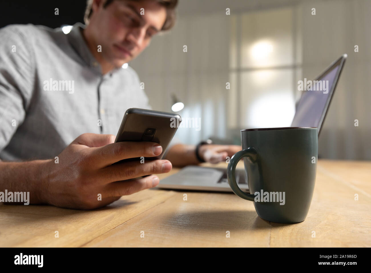 Young man using laptop computer and smartphone Stock Photo
