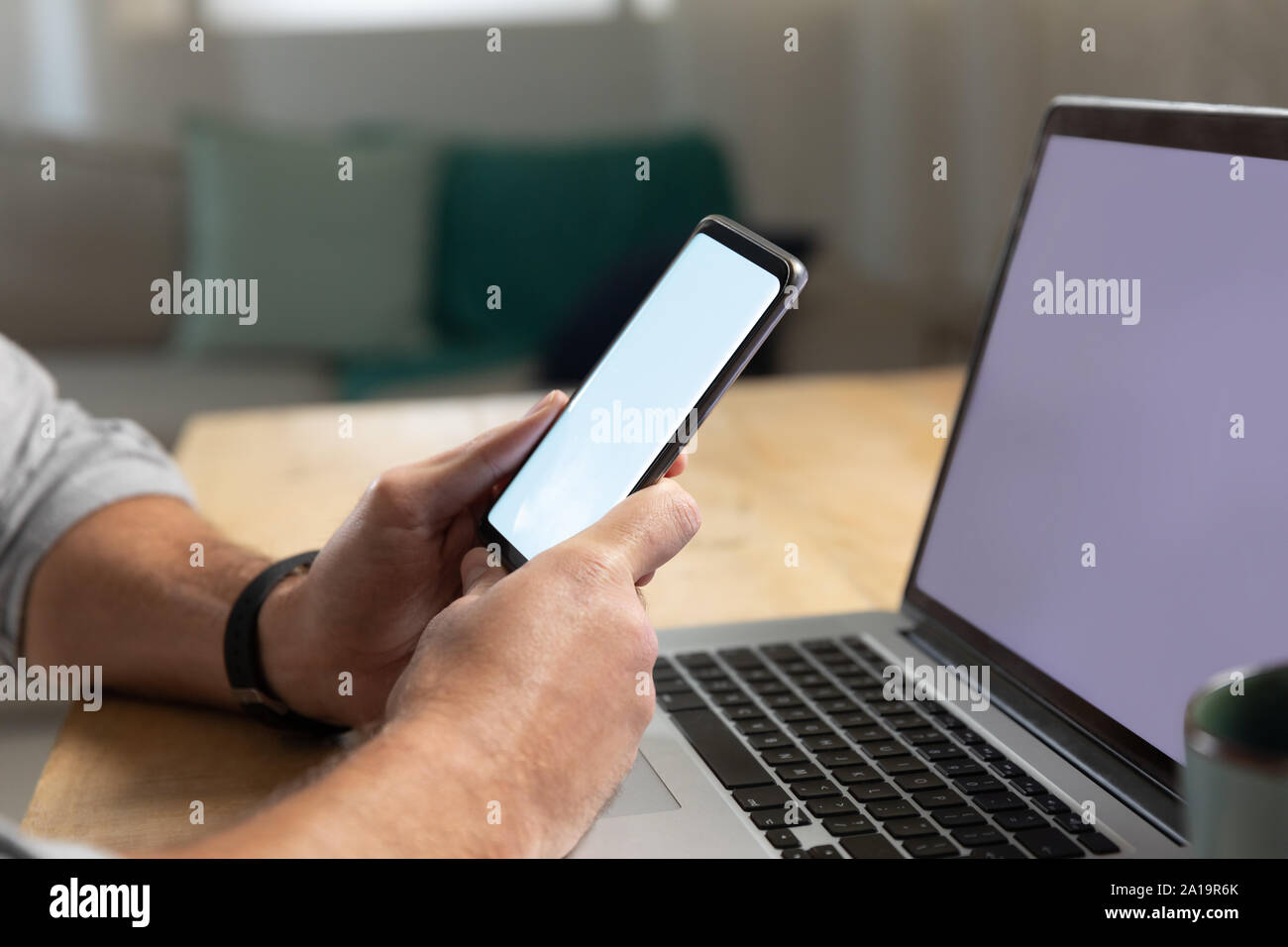 Young man using laptop computer and smartphone Stock Photo