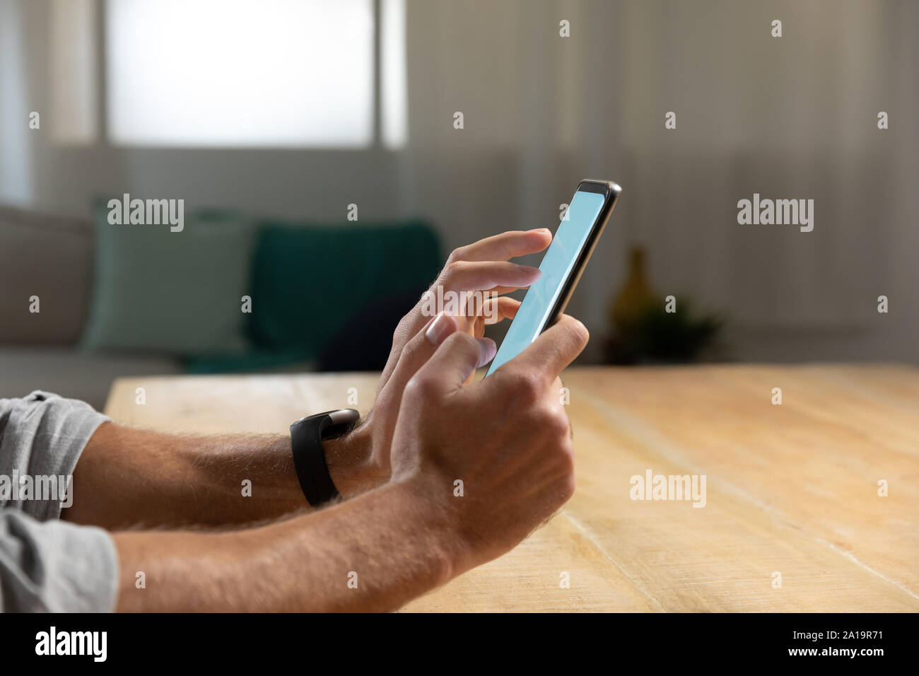 Young man at home using a smartphone Stock Photo