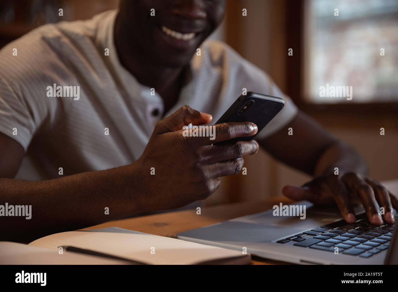 Young man using smartphone and laptop Stock Photo