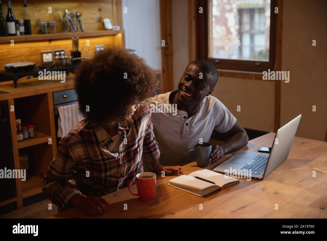Couple using a laptop in their kitchen Stock Photo