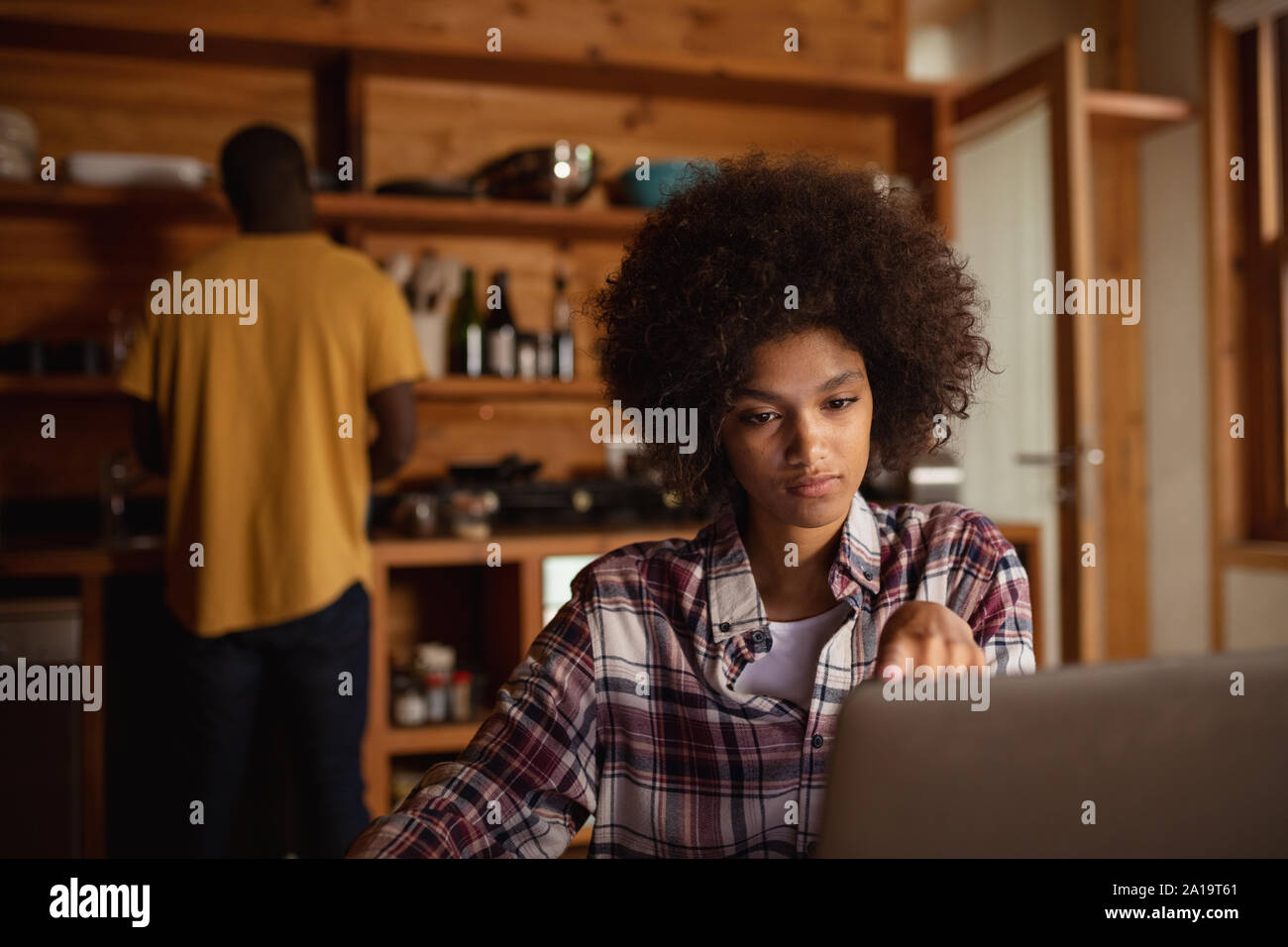 Young woman using laptop in a kitchen Stock Photo