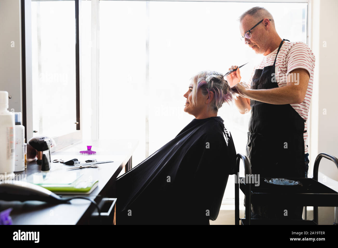 Male hairdresser and female client in hair salon Stock Photo - Alamy