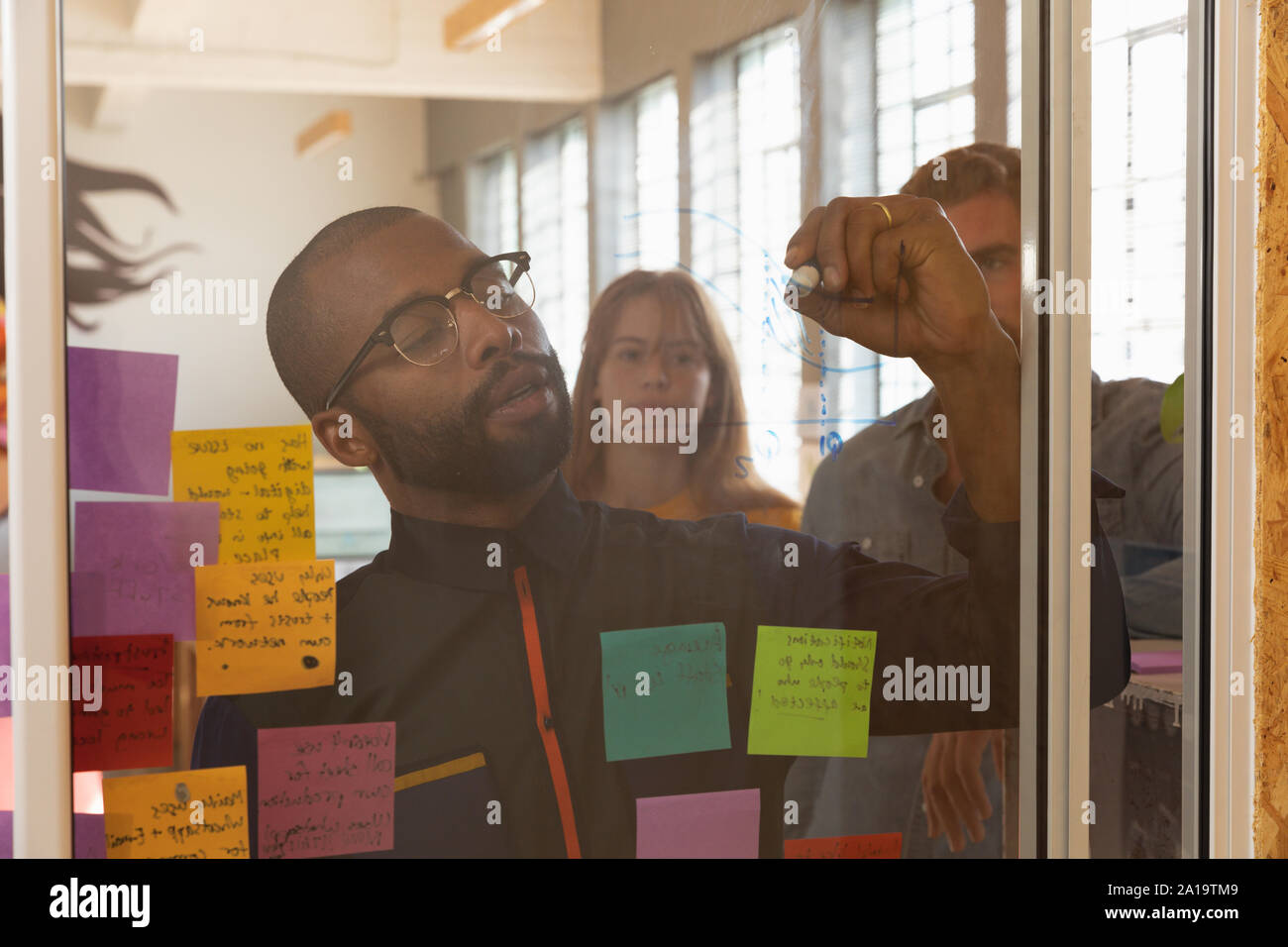Young creative professional man working in a sunlit office Stock Photo