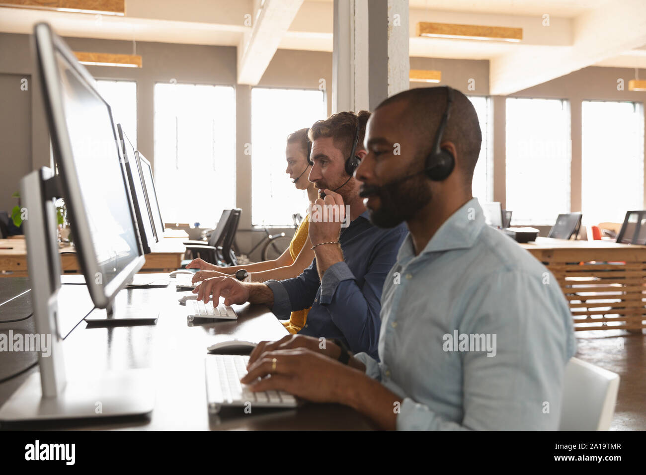 Young creative professionals working in a sunlit office Stock Photo