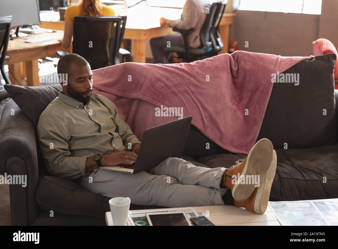 Young creative professional man working in a sunlit office Stock Photo