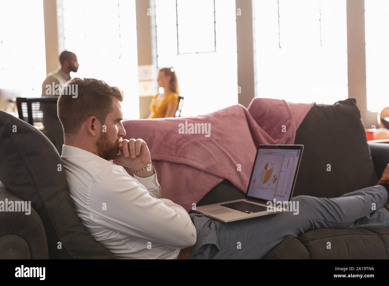 Young creative professionals working in a sunlit office Stock Photo