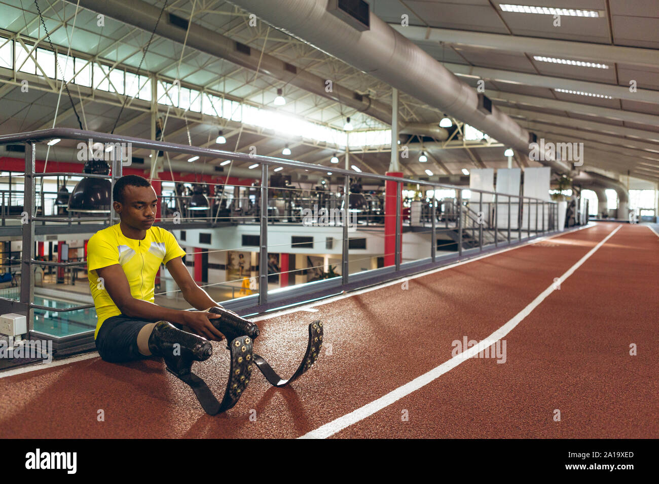 Disabled African American male athletic sitting on race track in fitness center Stock Photo