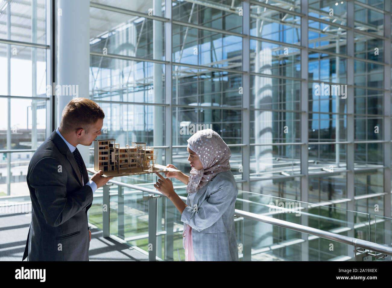 Male and female architects discussing over construction project in office Stock Photo
