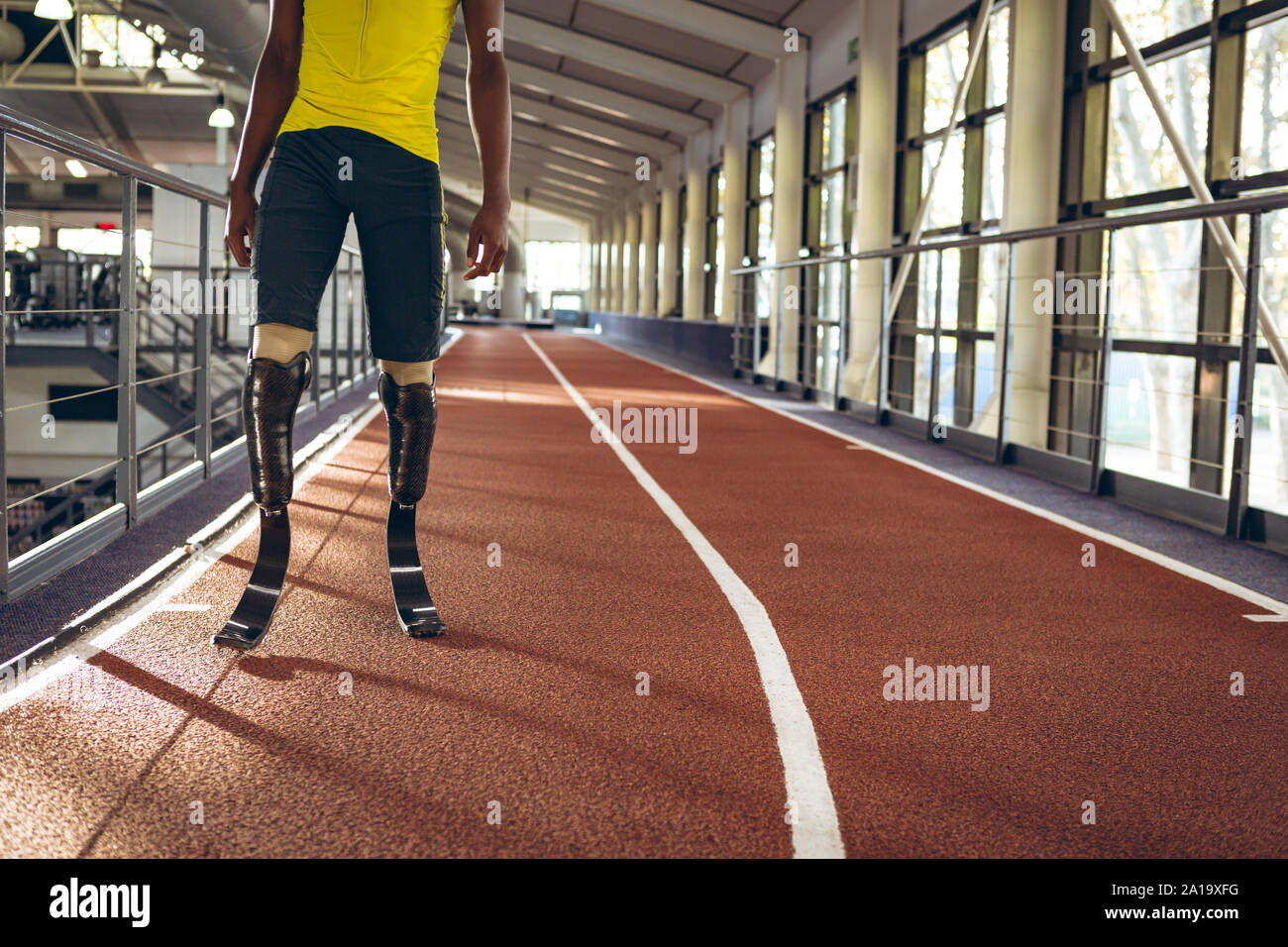 Disabled African American male athletic standing on running track in fitness center Stock Photo