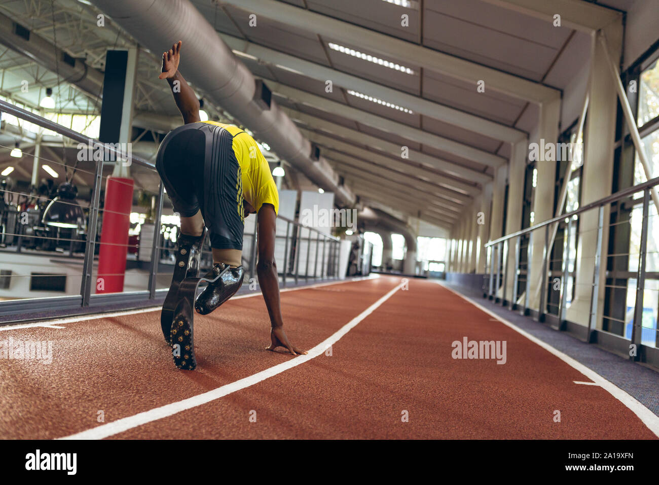 Disabled African American male athletic running on race track in fitness center Stock Photo