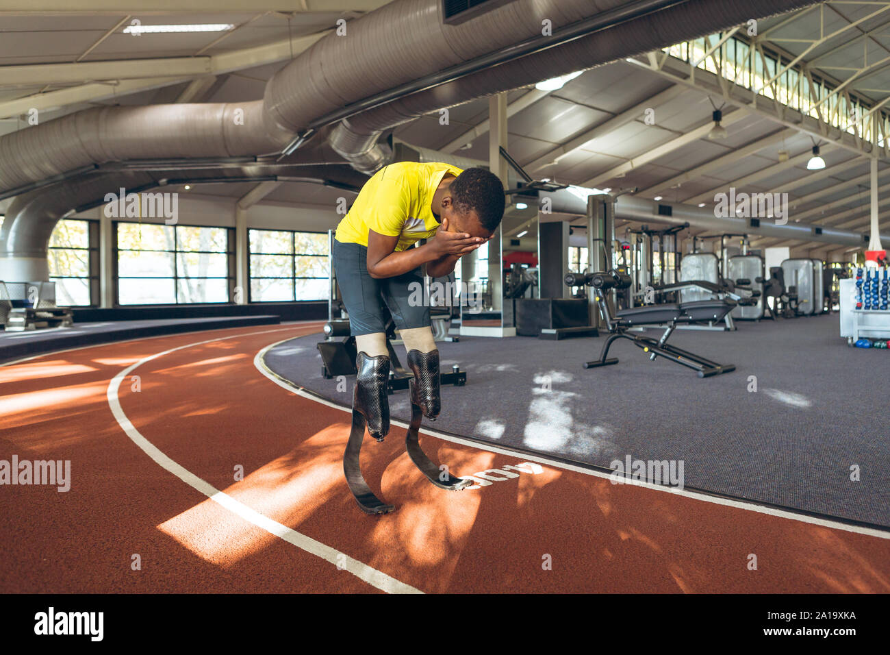 Disabled African American male athletic disappointed after losing race in fitness center Stock Photo