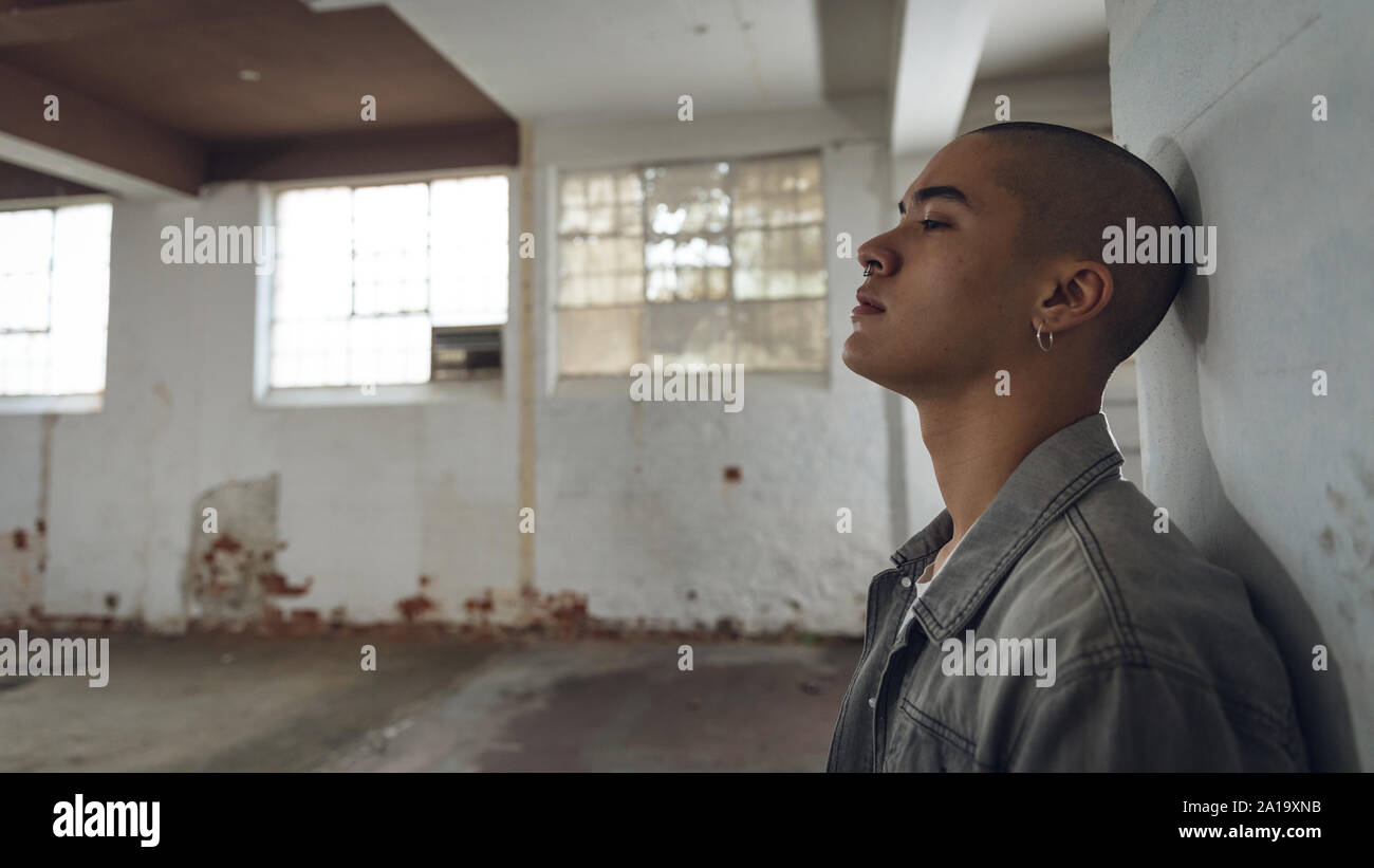 Young man inside an empty warehouse Stock Photo - Alamy
