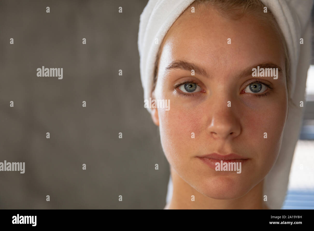 Portrait of young blonde woman with her hair wrapped in a towel Stock Photo
