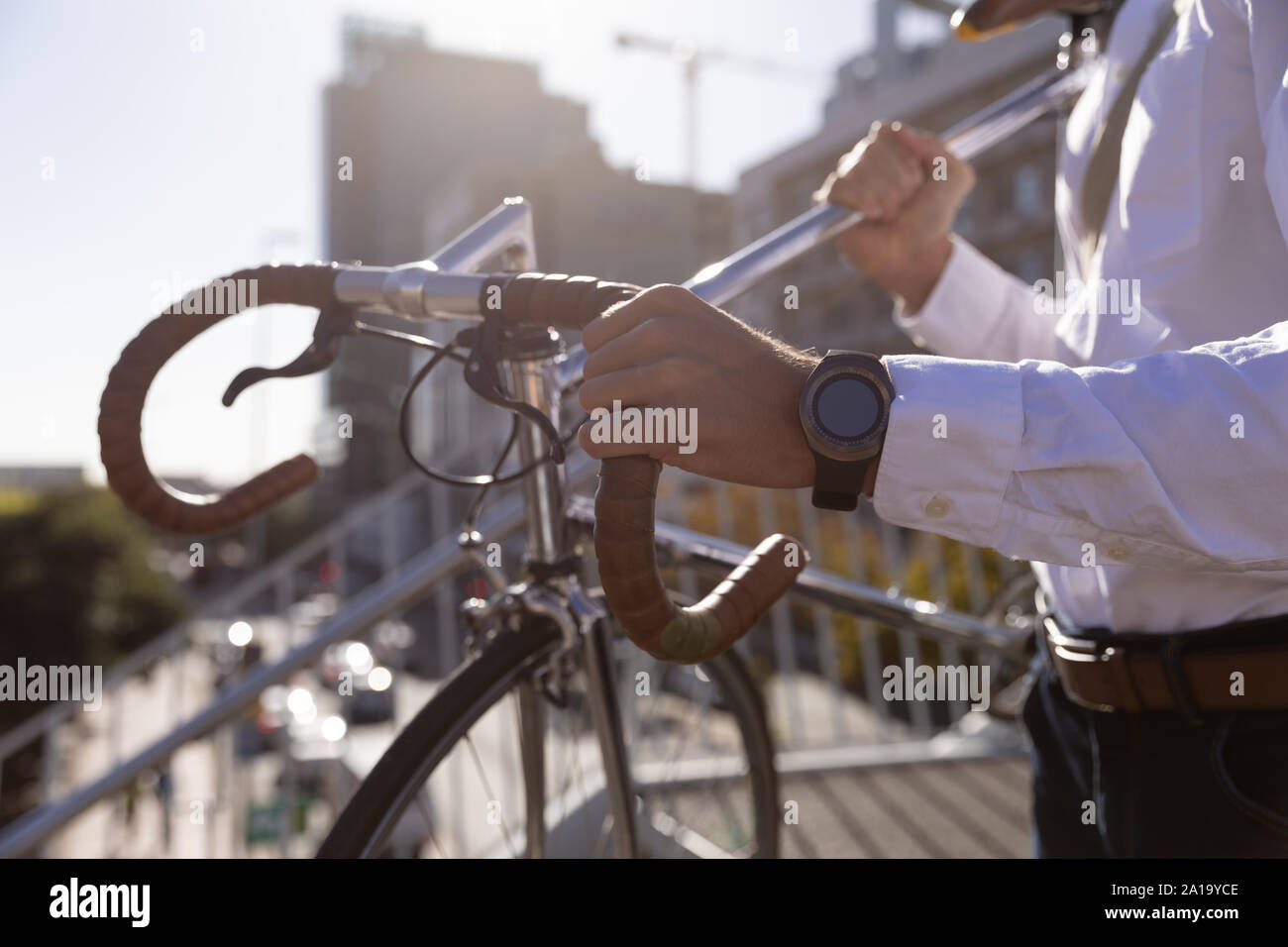 Young professional man carrying a bike Stock Photo