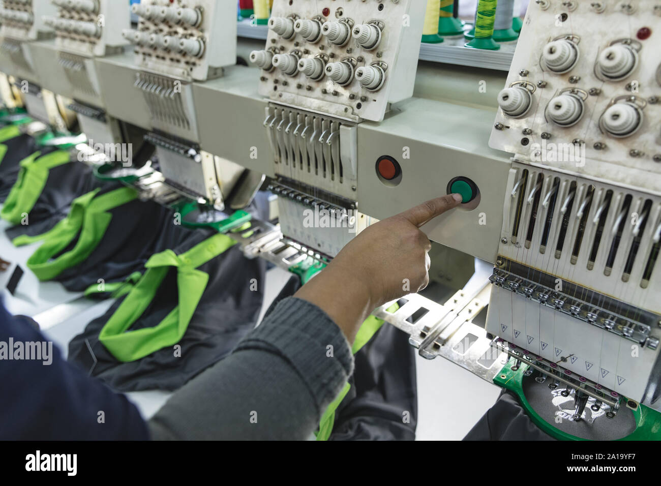 Woman operating a machine in a sports clothing factory Stock Photo