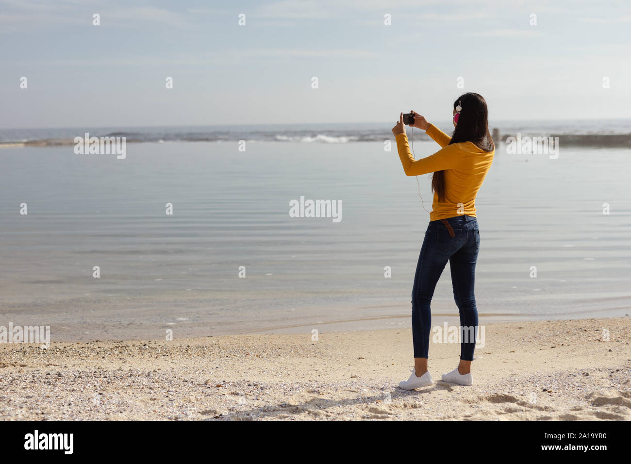 Young woman listening to music and taking photos Stock Photo