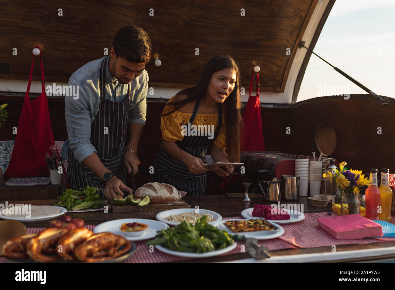 young mixed race couple busy preparing food stall Stock Photo - Alamy