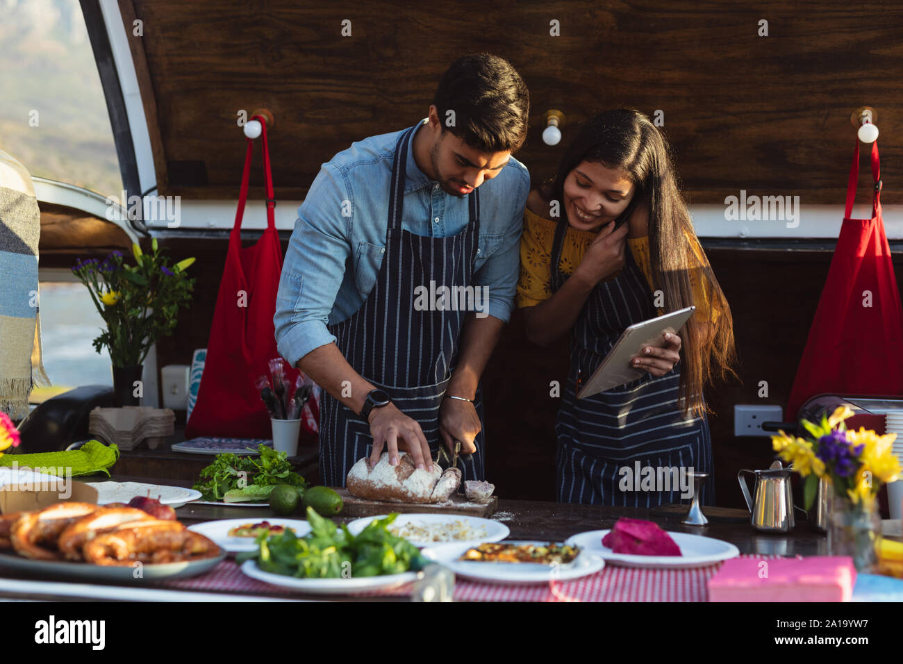young mixed race couple busy preparing food stall Stock Photo - Alamy