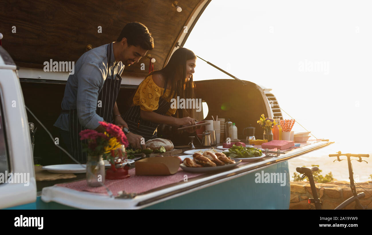 young mixed race couple busy preparing food stall Stock Photo - Alamy