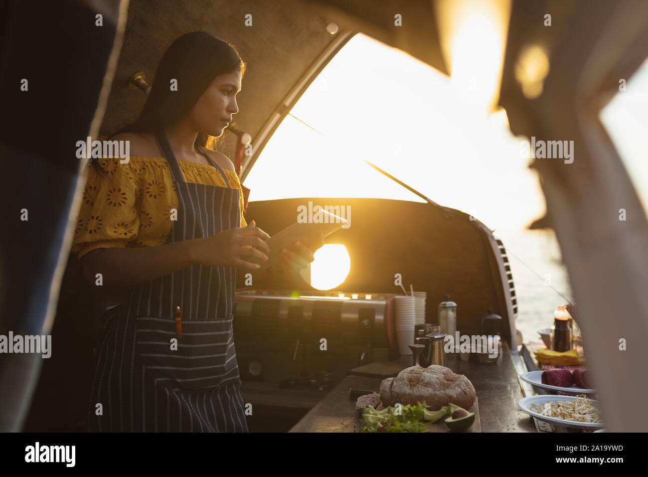 Young woman using tablet in food truck Stock Photo
