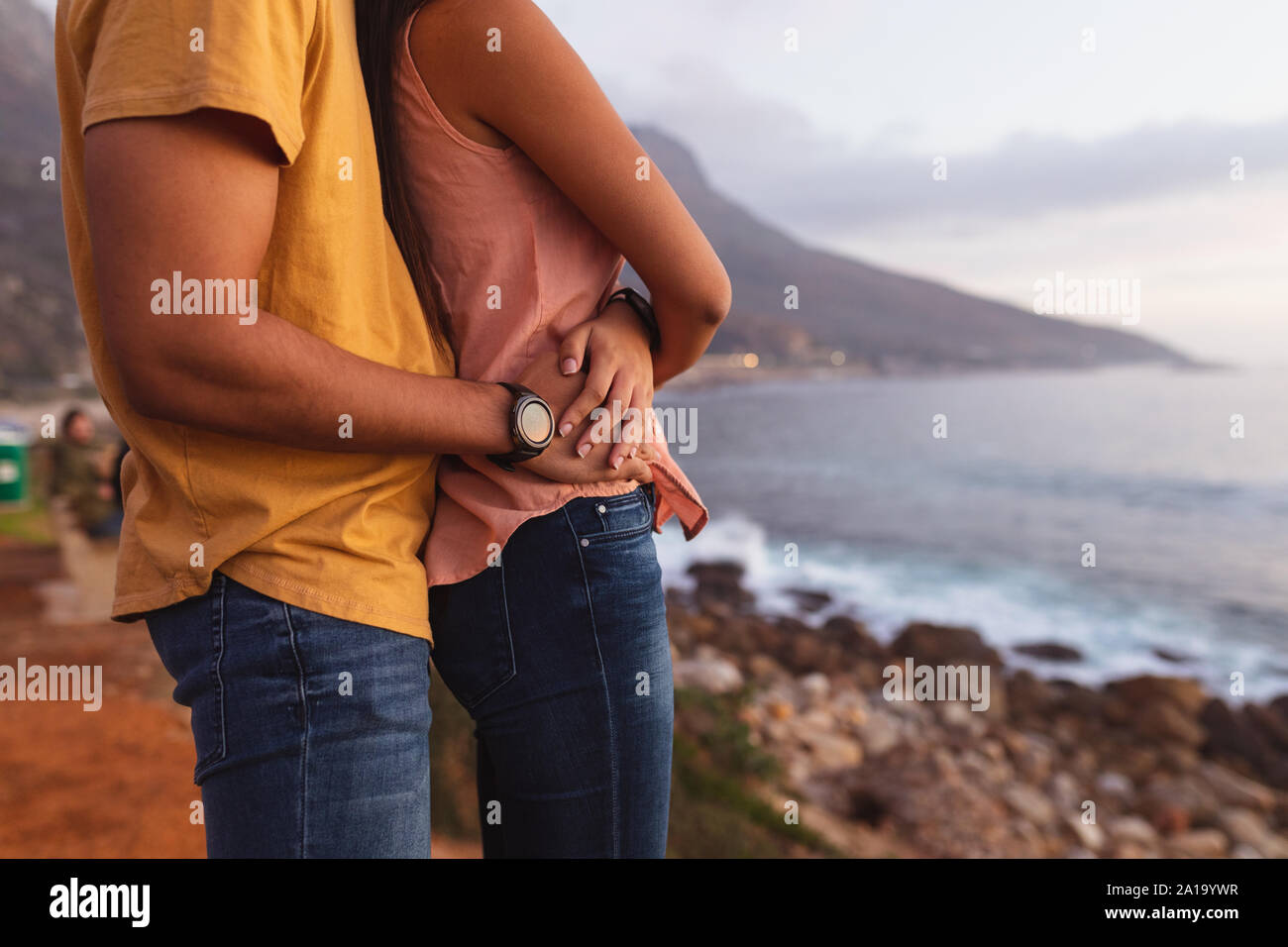 young mixed race couple standing on a beach Stock Photo