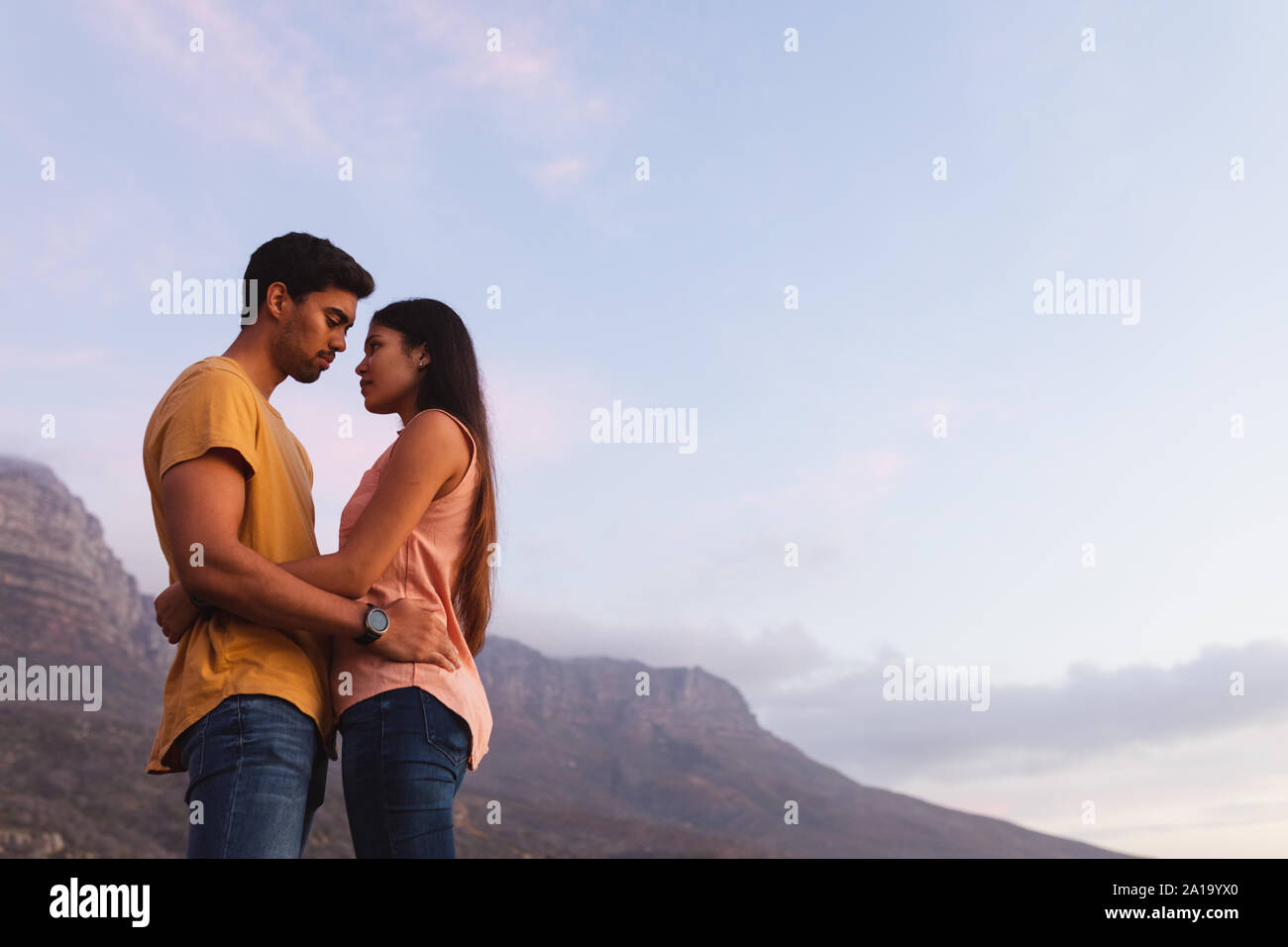 young mixed race couple standing on a beach Stock Photo
