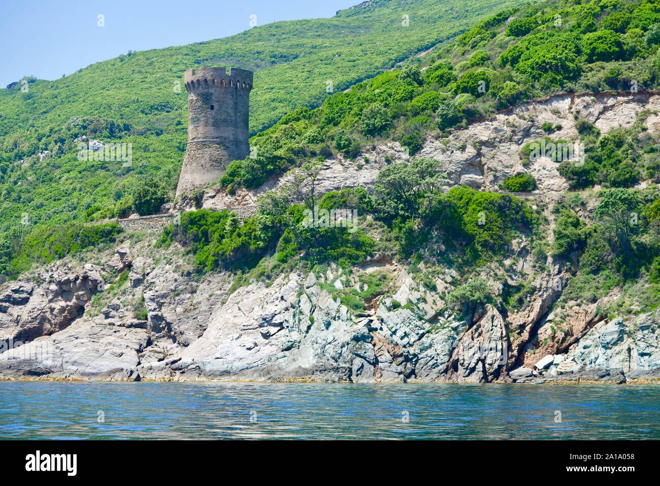 Old Genoese tower on a greened cliff at the turquoise sea Stock Photo