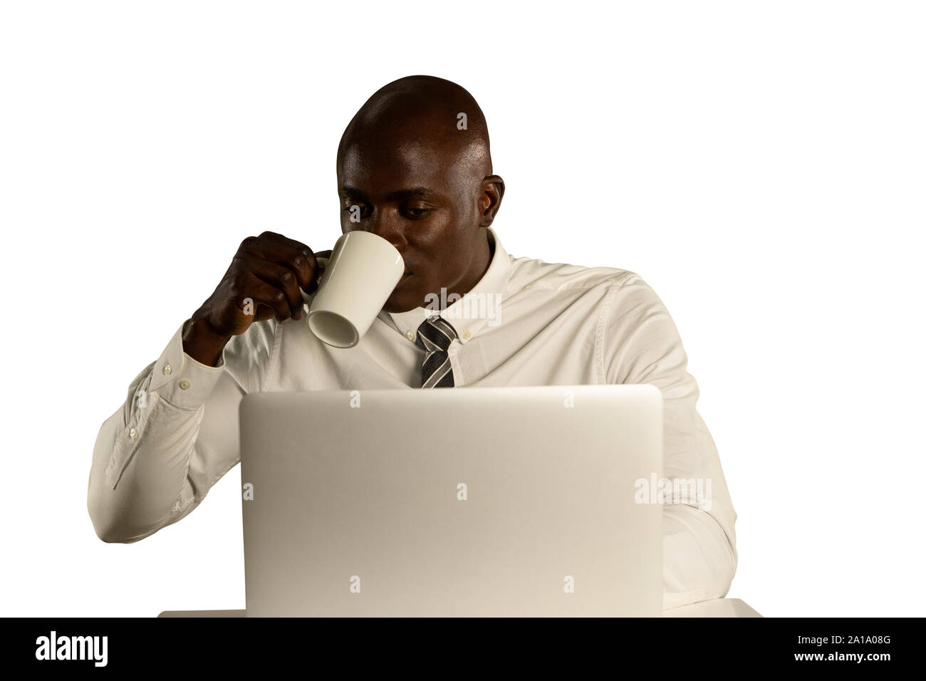 Businessman using a laptop and drinking coffee Stock Photo