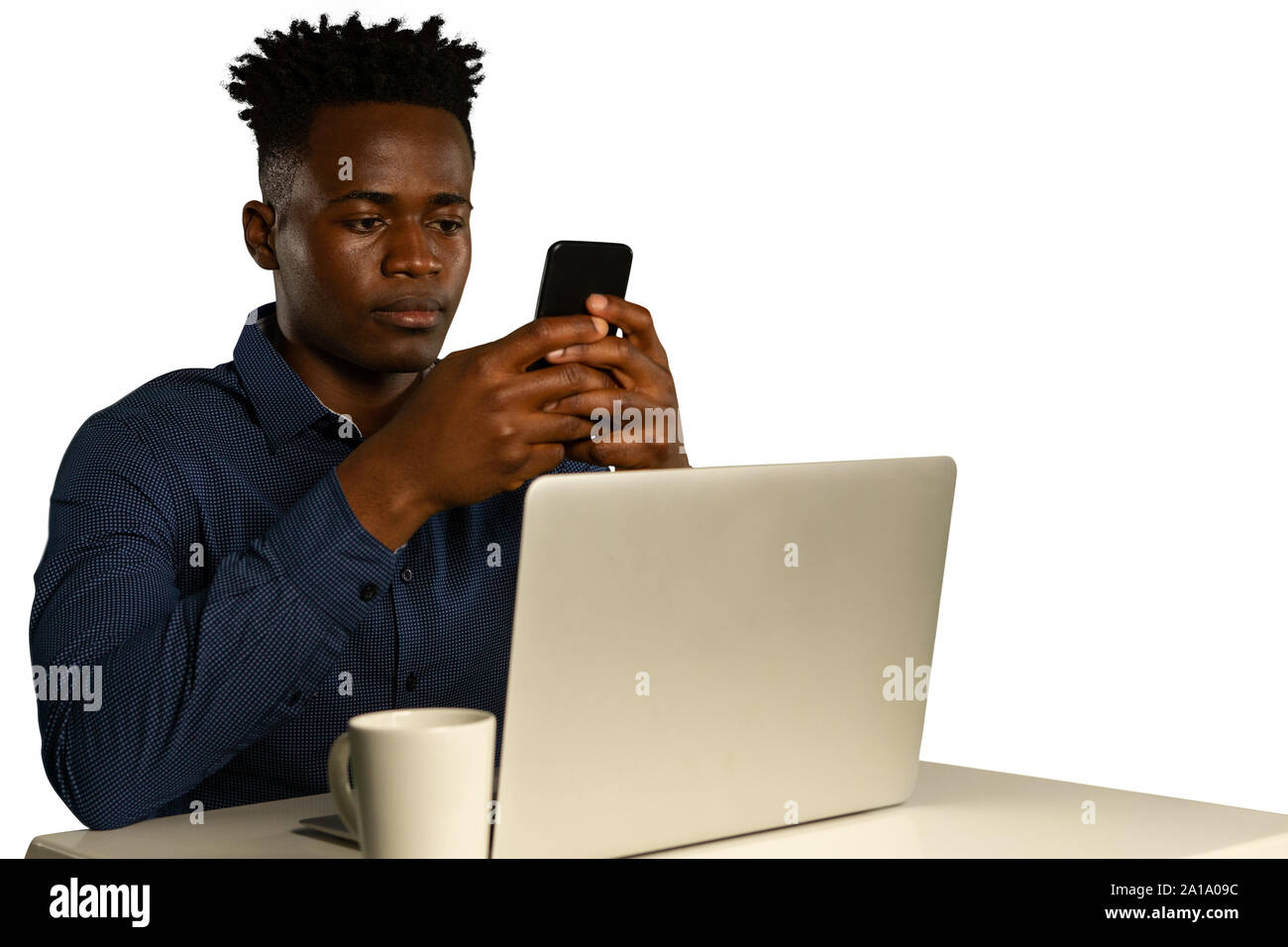 Young businessman using a laptop and a smartphone Stock Photo