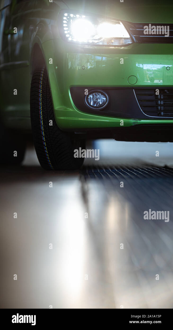 Car in a garage for maintenance, oil/tyre change (shallow DOF; color toned image) Stock Photo