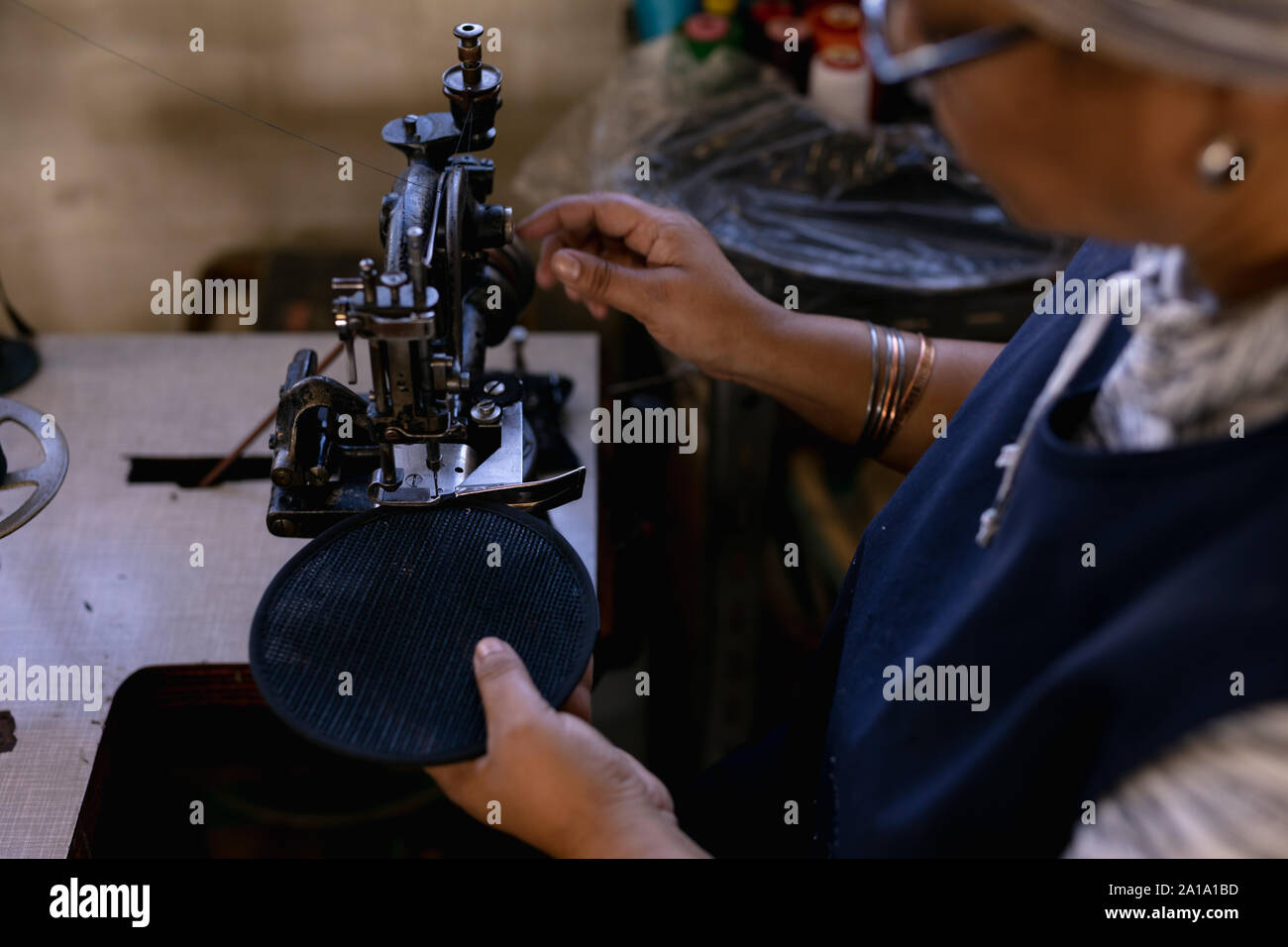 Woman using sewing machine in a hat factory Stock Photo
