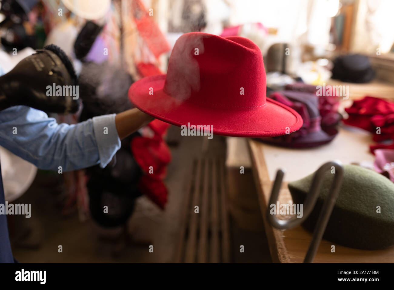 Red hat is steam finished in a hat factory Stock Photo