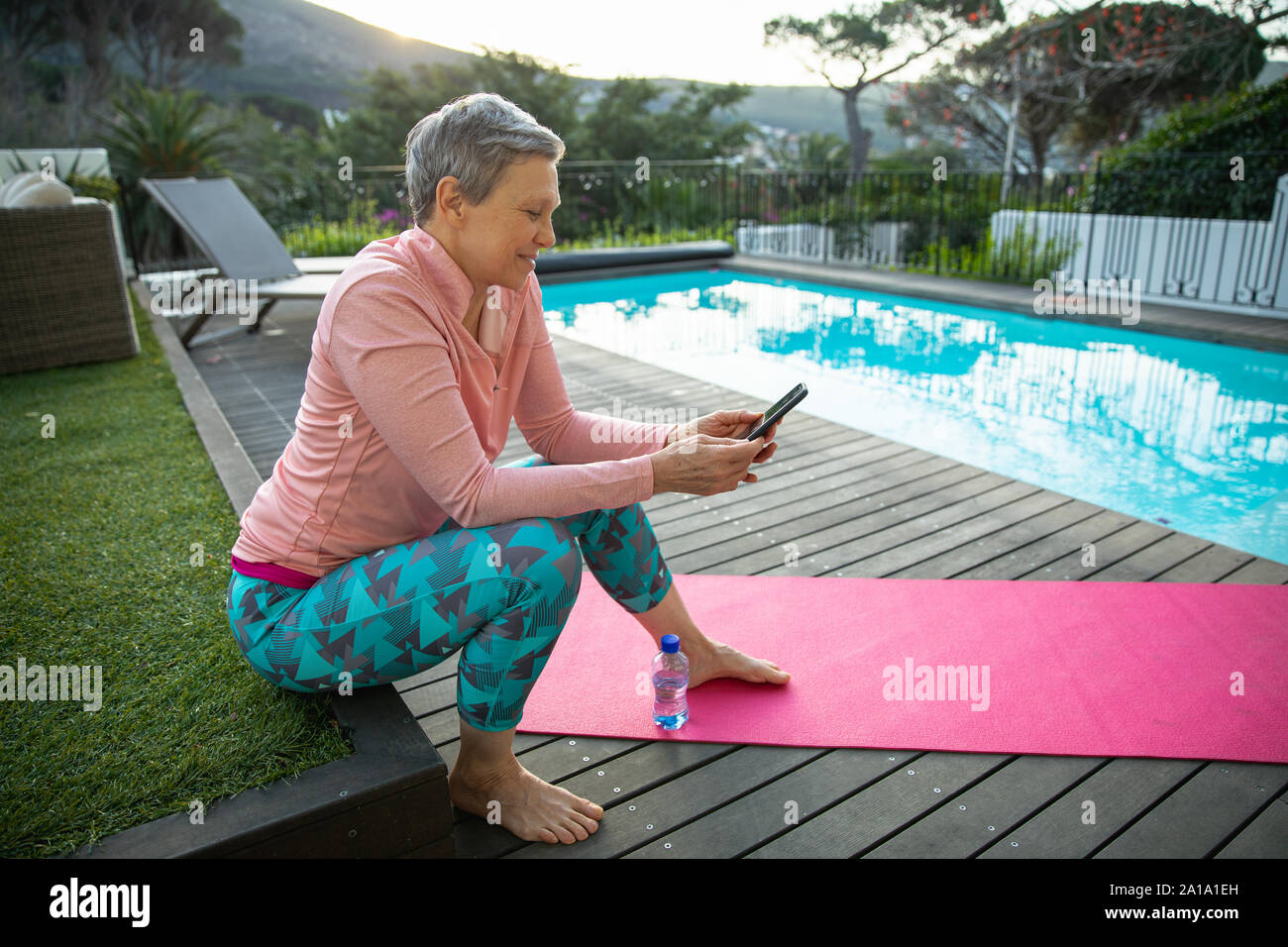Mature woman alone at home using smartphone outside Stock Photo