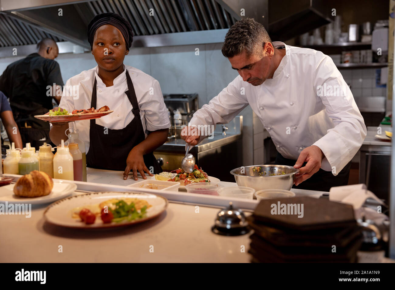 Chefs working in busy restaurant kitchen Stock Photo