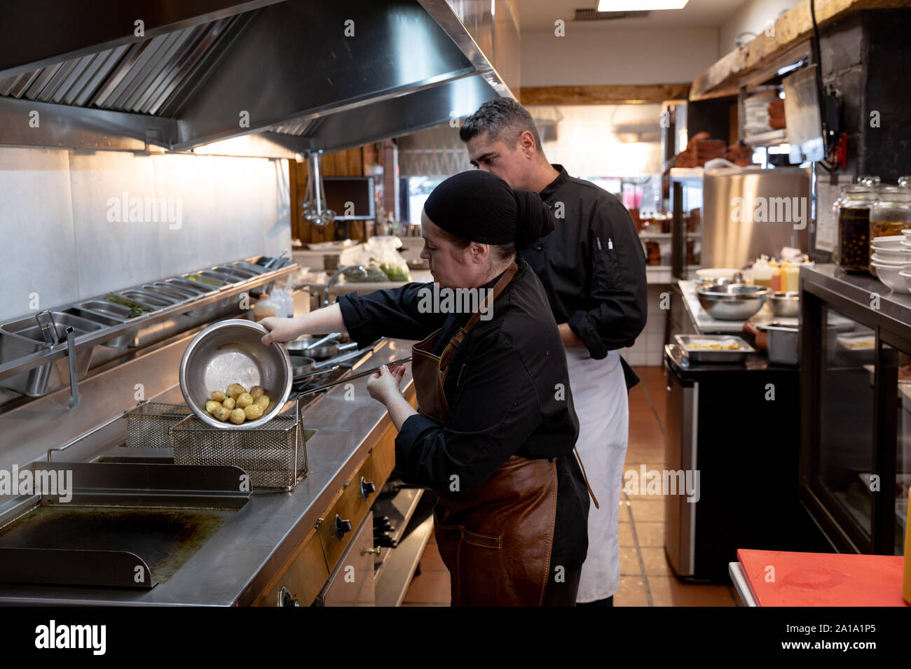 Chefs working in busy restaurant kitchen Stock Photo
