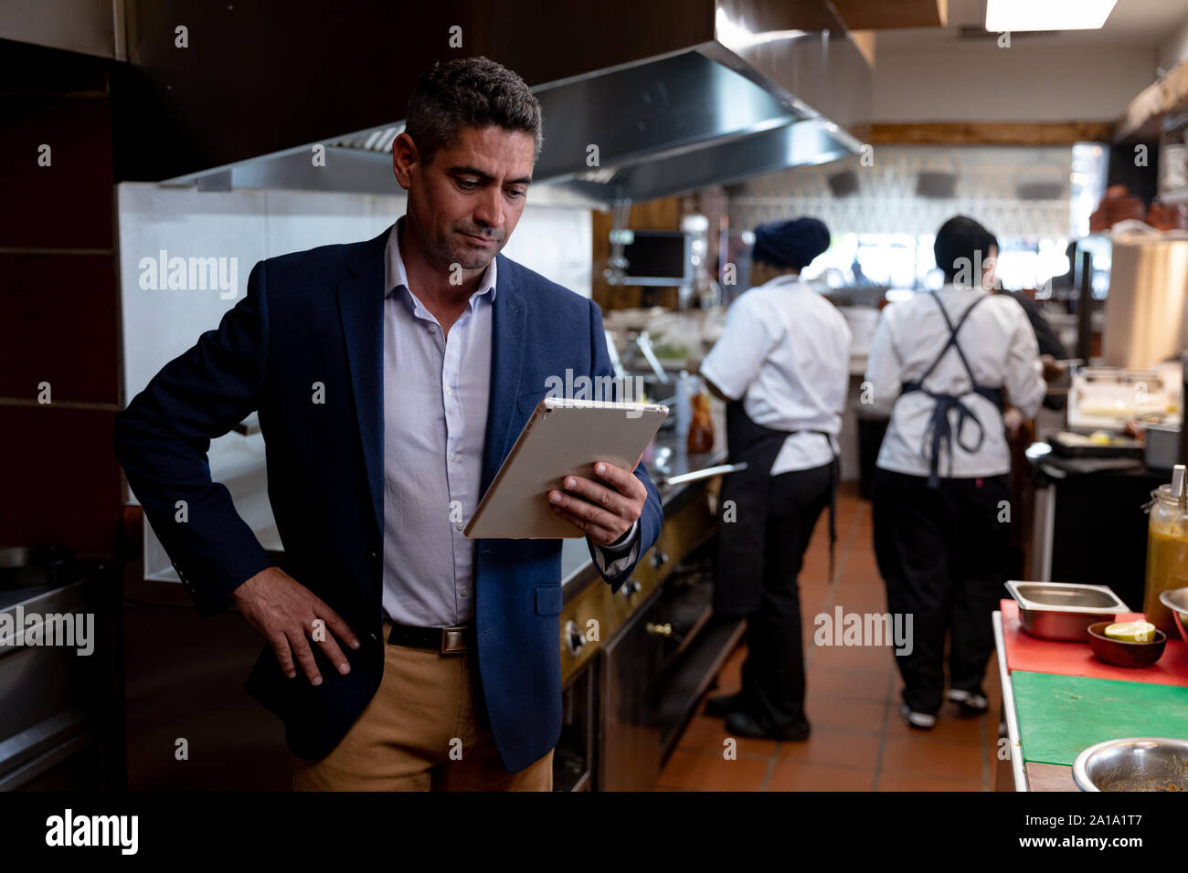 Restaurant manager using a tablet in a kitchen Stock Photo