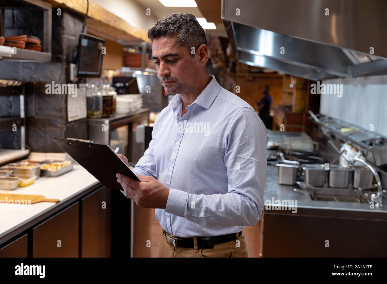 Restaurant manager holding a clipboard in a kitchen Stock Photo