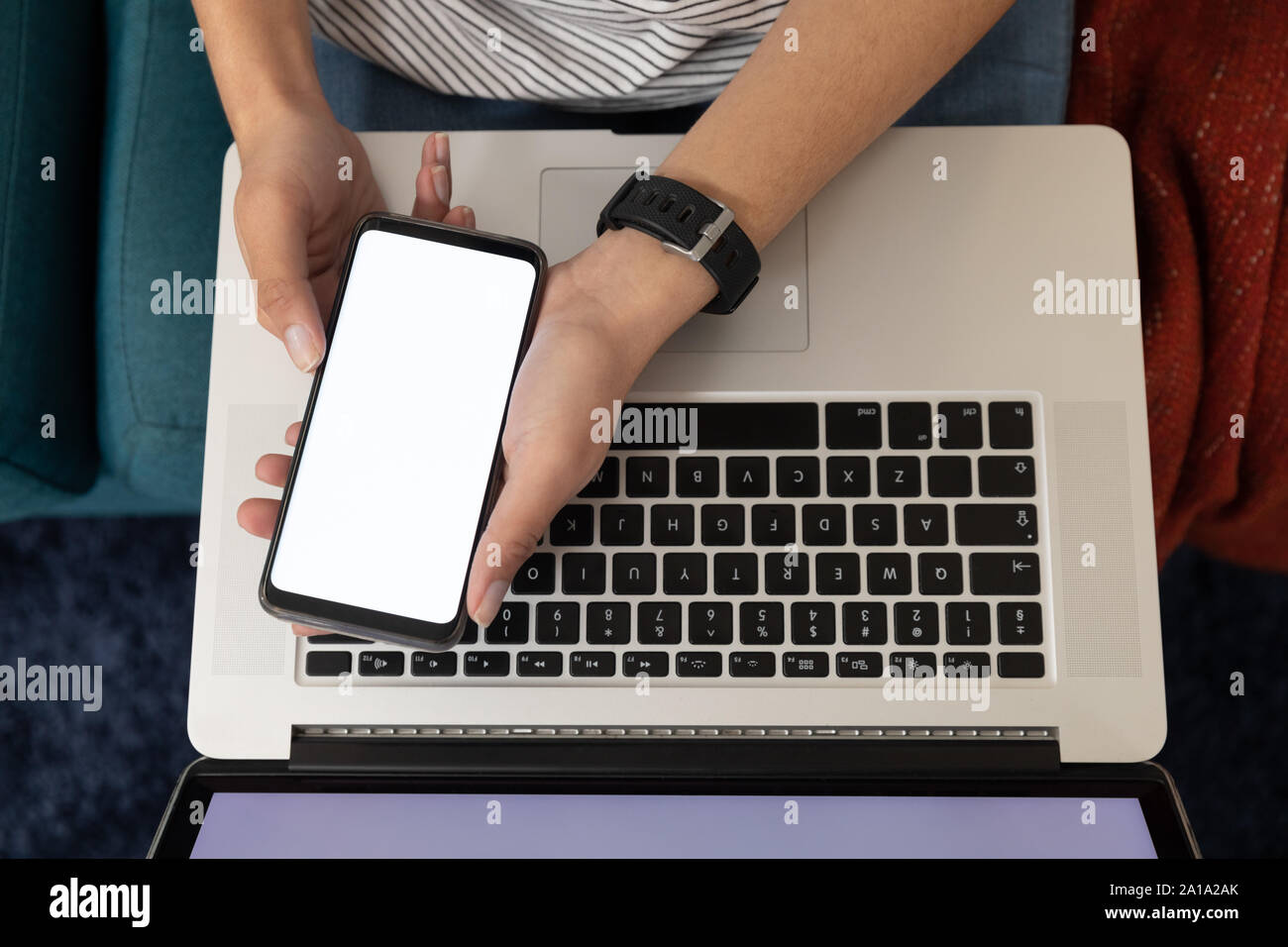 Woman using a smartphone and laptop Stock Photo