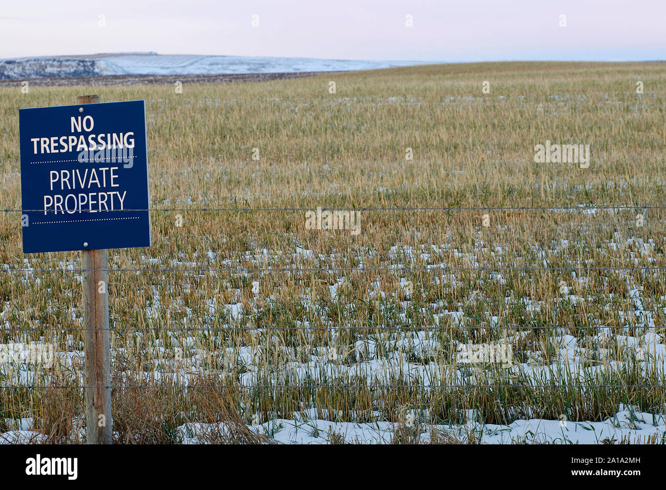 A No Trespassing, Private property sign posted on farmland which is
