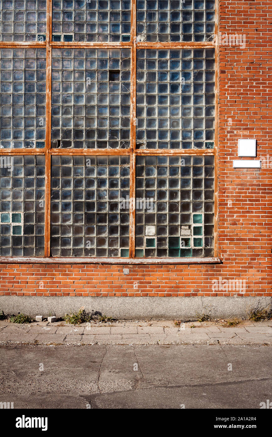 Red brick wall with glass block window. Architecture detail Stock Photo